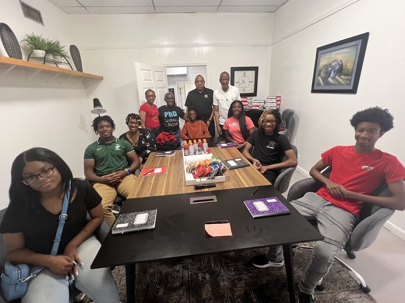 Group photo of students, educators, and veteran mentors around the table at the STEAM camp