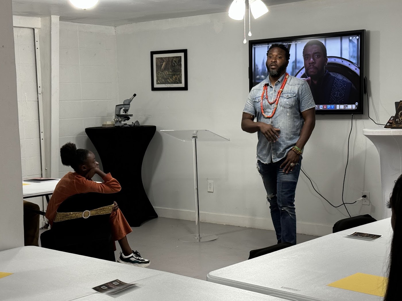 A veteran mentor leads a cultural STEAM lesson for an Africatown student