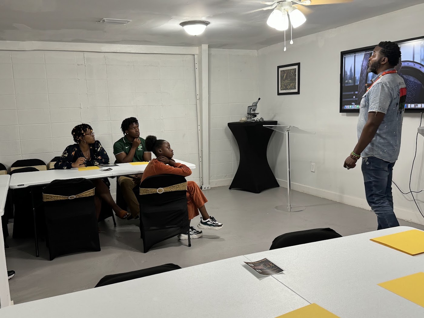 Students watch and take notes as a mentor teaches during the coding and film camp
